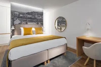 a bedroom with a bed and a desk and a chair at Mamaison Residence Downtown Prague in Prague