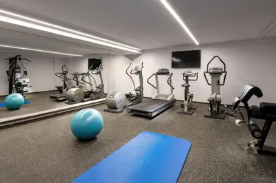 a gym with several tread machines and a mirror at Mamaison Residence Downtown Prague in Prague