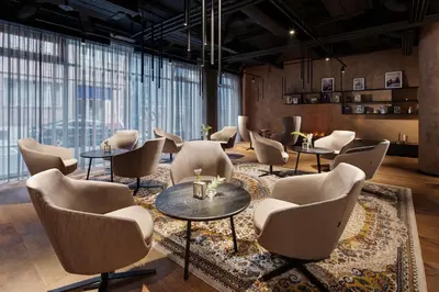 a waiting room with chairs and tables and windows at Mamaison Residence Downtown Prague in Prague