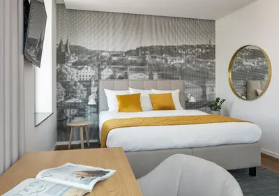 a bedroom with a bed and a table and a mirror at Mamaison Residence Downtown Prague in Prague