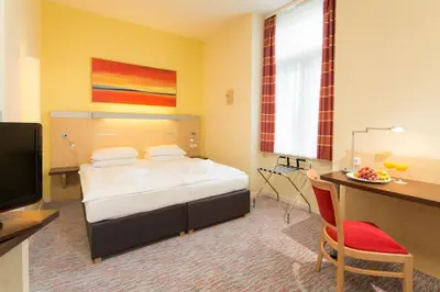 a hotel room with a bed and a desk with a computer at Exe City Park Hotel in Prague
