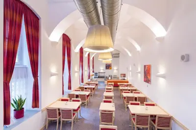 a row of tables and chairs in a room with windows at Exe City Park Hotel in Prague