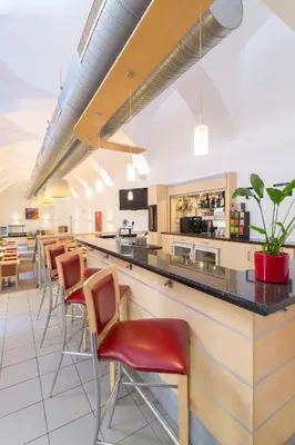 a bar in a restaurant with chairs and a counter at Exe City Park Hotel in Prague
