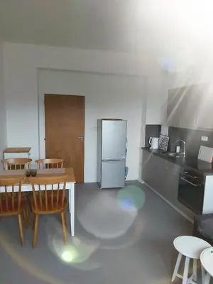 a kitchen with a table and chairs and a refrigerator at Apartmán Tony Slapy in Slapy