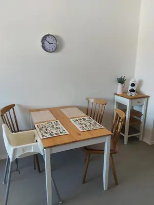 a dining room table with chairs and a clock on the wall at Apartmán Tony Slapy in Slapy