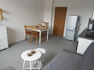 a kitchen with a table and chairs and a refrigerator at Apartmán Tony Slapy in Slapy