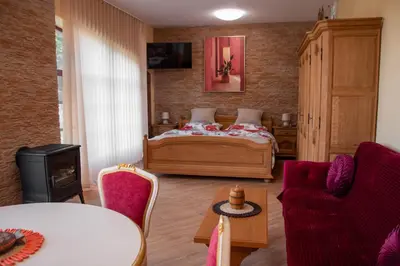 a bedroom with a bed and a table and chairs at Zámeček Kaliště in Poddubí