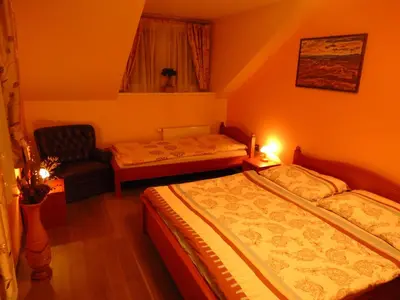 a small bedroom with two beds and a chair at Zámeček Kaliště in Poddubí