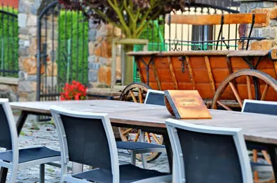 a wooden table and chairs with a book on it at Zámeček Kaliště in Poddubí