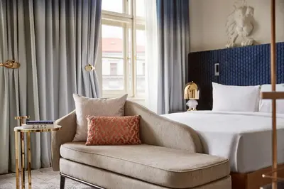 a bedroom with a bed and a couch and a chair at Andaz Prague, By Hyatt in Prague