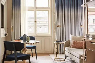 a living room with a couch and a table and a window at Andaz Prague, By Hyatt in Prague
