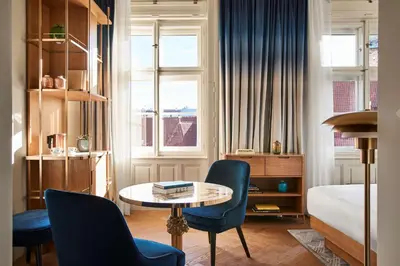 a room with a table and chairs and a bed at Andaz Prague, By Hyatt in Prague