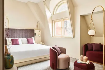 a bedroom with a large bed and a chair at Andaz Prague, By Hyatt in Prague