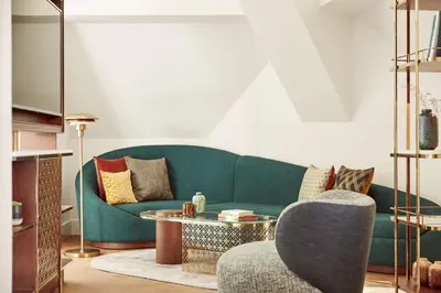 a living room with a green couch and a table at Andaz Prague, By Hyatt in Prague