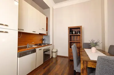 a kitchen with a sink and a table with a dining room at Janackovo - Riverside Residence in Prague