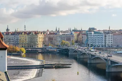 a bridge over a river in a city with buildings at Janackovo - Riverside Residence in Prague
