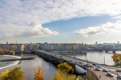 a bridge over a river with cars on it at Janackovo - Riverside Residence in Prague