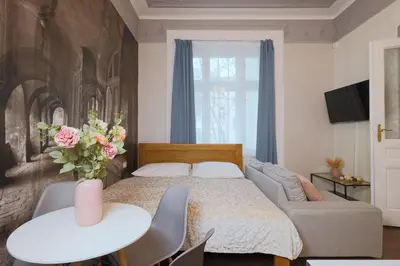 a bedroom with a bed and a couch and a table at Janackovo - Riverside Residence in Prague