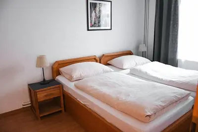 two twin beds in a bedroom with a night stand and a lamp at Villa Jinonice in Prague