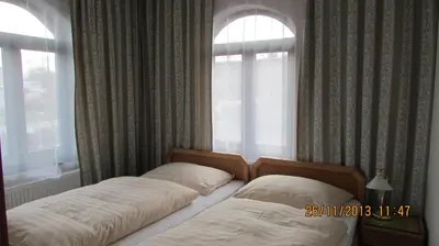 two beds in a bedroom with two windows at Villa Jinonice in Prague