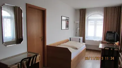 a hotel room with a bed and a tv at Villa Jinonice in Prague