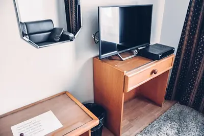 a television on a wooden dresser with a mirror at Villa Jinonice in Prague