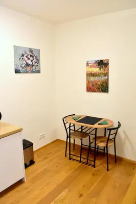 a room with a table and two paintings on the wall at Airstay Prague apartment: Grebovka in Prague