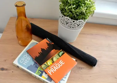 a table with a book and a bottle and a plant at Airstay Prague apartment: Grebovka in Prague