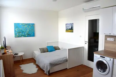 a bedroom with a bed and a washing machine at Airstay Prague apartment: Grebovka in Prague