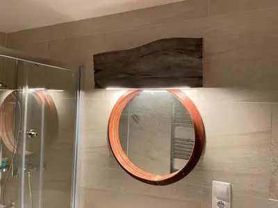 an orange mirror on the wall of a bathroom at Harfa Apartment 30 in Prague
