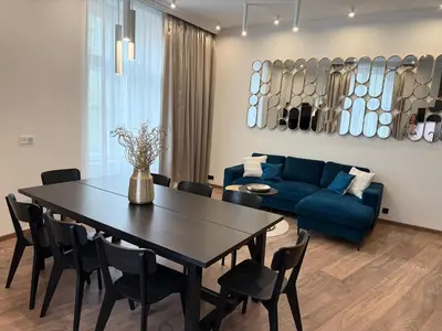 a living room with a table and a blue couch at Luxury Residence Kmochova in Prague
