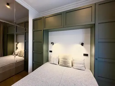a bedroom with a bed and a mirrored wall at Luxury Residence Kmochova in Prague