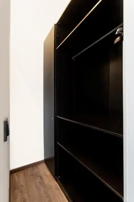 a black book shelf in a room with a wooden floor at Luxury Residence Kmochova in Prague