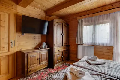 a bedroom with two beds and a flat screen tv at Private summer house with swimming pool, beach bar and pit for football and volleyball in Hvězdonice