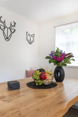 a table with a bowl of fruit and a vase of flowers at Private summer house with swimming pool, beach bar and pit for football and volleyball in Hvězdonice