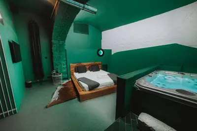 a green room with a bed and a bath tub at SPA SPA Letná in Prague