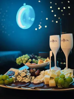 a plate of cheese and grapes and wine glasses at SPA SPA Letná in Prague