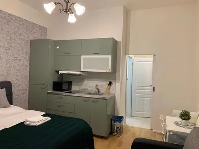 a bedroom with a bed and a kitchen with a sink at Charles Square Prague Apartment in Prague