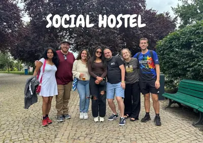 a group of people posing for a picture in front of a sign at Onefam Home in Prague
