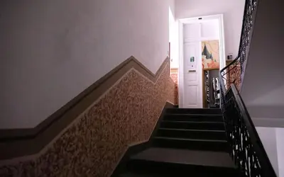 a hallway with stairs with a white door at Onefam Home in Prague