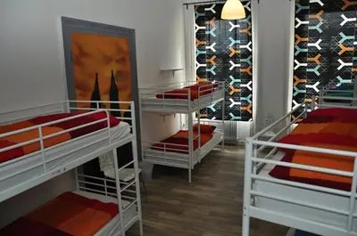 a room with three bunk beds and a wall of wine bottles at Onefam Home in Prague