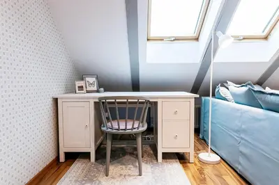 a desk with a chair next to a bed at ATTIC APARTMENT on WATERFRONT / VIEW / NETFLIX in Prague