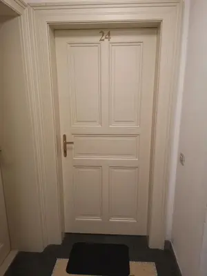 a white door with a black mat in front of it at quiet apartment in Prague center in Prague