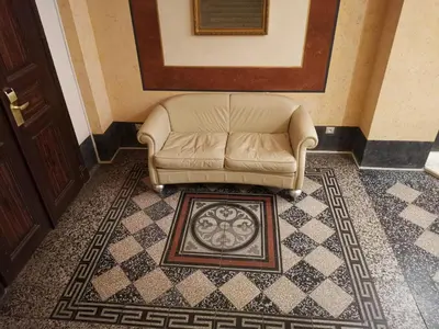 a brown leather couch sitting in a room with a rug at quiet apartment in Prague center in Prague