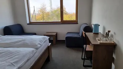 a bedroom with a bed and a desk and a window at Pension Vinařství Klučov in Klučov
