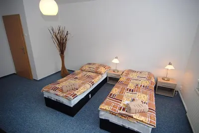 two beds in a hotel room with two lamps at Apartmany Chodov in Prague