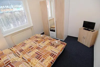 a bedroom with a bed and a television and a window at Apartmany Chodov in Prague