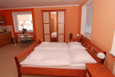 a bedroom with a large bed with white sheets at Apartmany Chodov in Prague