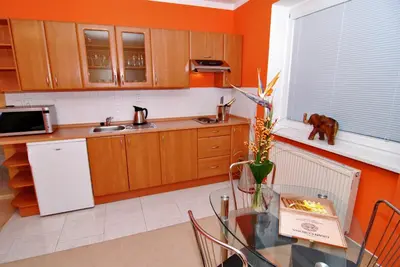 a kitchen with a glass table and a white refrigerator at Apartmany Chodov in Prague