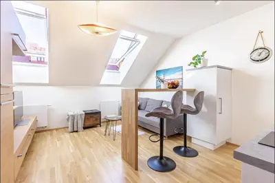 a bedroom in a loft with a desk and a chair at Minimalist's Dream - sunny cozy studio in New Town in Prague